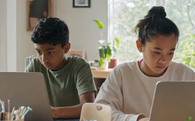 Two children at an AI summer camp for kids ages 8 to 16 working on laptops